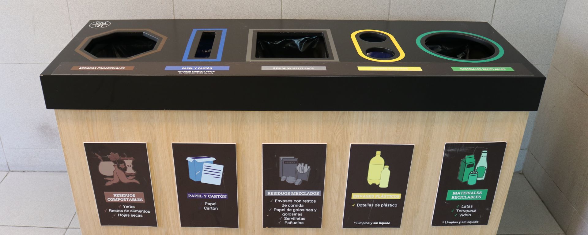 Fotografía de estación de residuos reciclados en la UM, con cinco clasificaciones